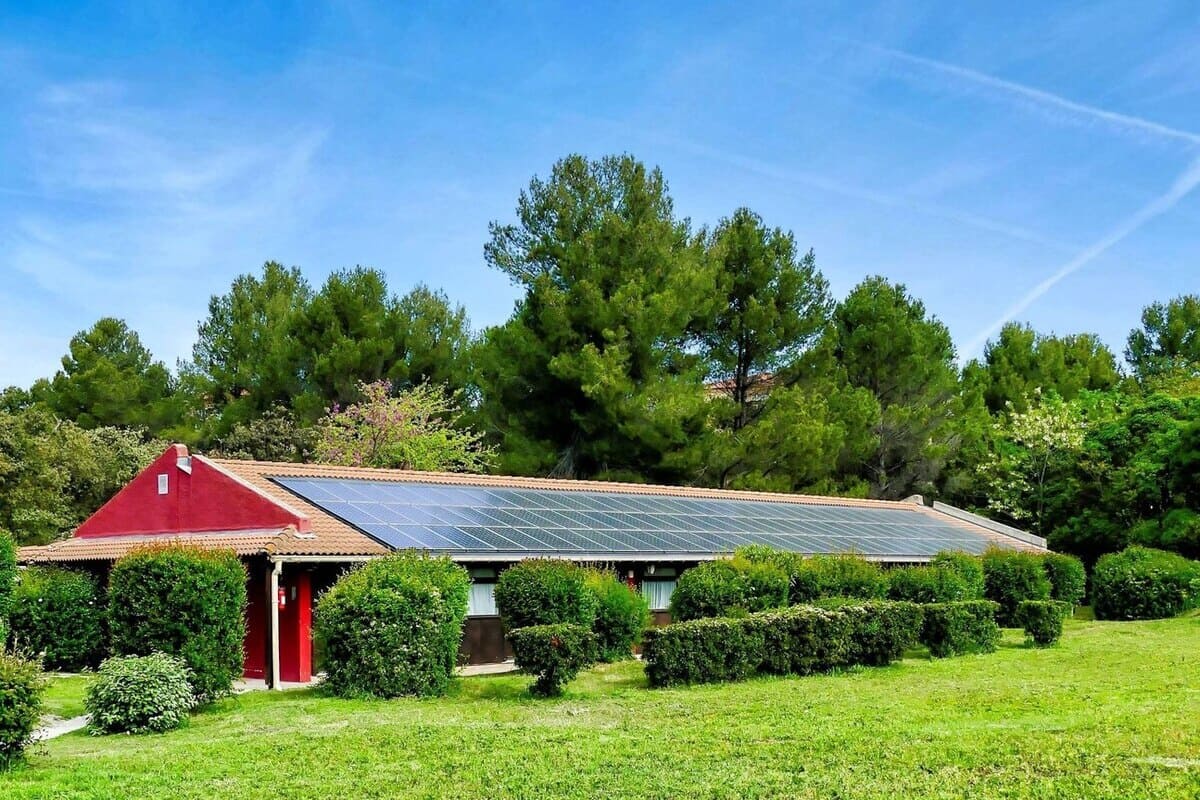 Vertical shot of a small house with solar panels in the green field in the Canary Islands